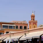 Market stalls with a minaret in the background.