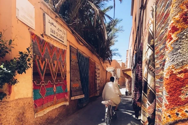 a man riding a bike down a narrow street