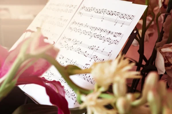 Elegant Sheet Music On Stand Through Flowers