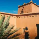 Woman walks into a moroccan kasbah courtyard