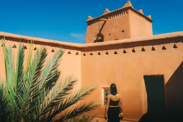 Woman walks into a moroccan kasbah courtyard